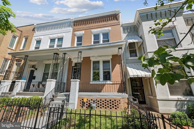 1306 E St NE, Washington, DC 20002 - townhome / multi-family property with brick siding, a porch, and a fenced front yard