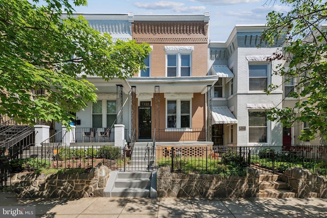 1306 E St NE, Washington, DC 20002 - view of property featuring brick siding, covered porch, and a fenced front yard