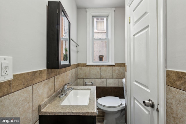 1306 E St NE, Washington, DC 20002 - bathroom featuring tile walls, toilet, wainscoting, and vanity