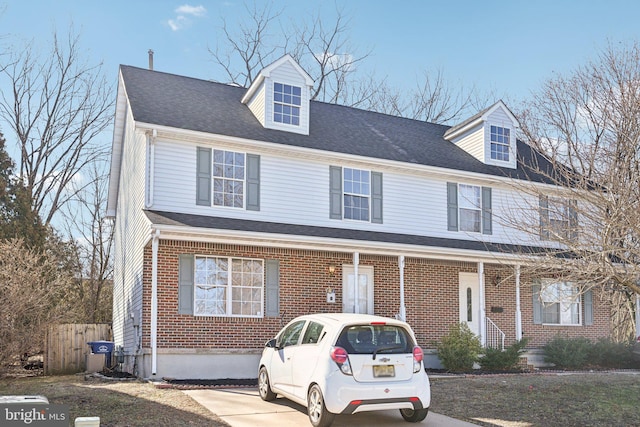 multi unit property featuring fence, brick siding, and roof with shingles