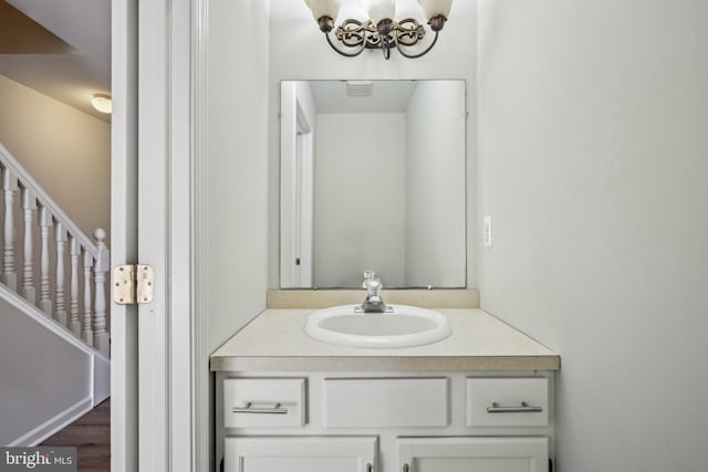 bathroom featuring vanity, wood finished floors, and a chandelier