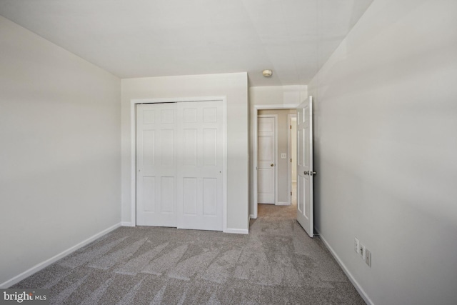 unfurnished bedroom featuring a closet, carpet flooring, and baseboards