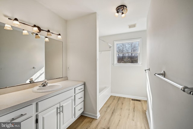 full bathroom featuring visible vents, vanity, baseboards, and wood finished floors