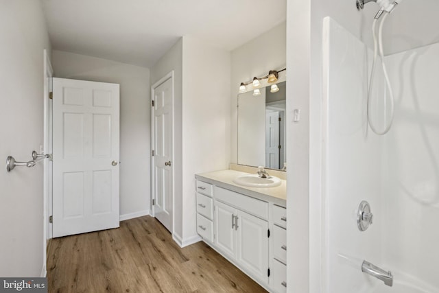 full bath featuring vanity, baseboards, and wood finished floors