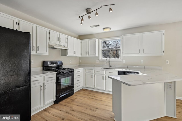 kitchen with visible vents, under cabinet range hood, a peninsula, black appliances, and a sink