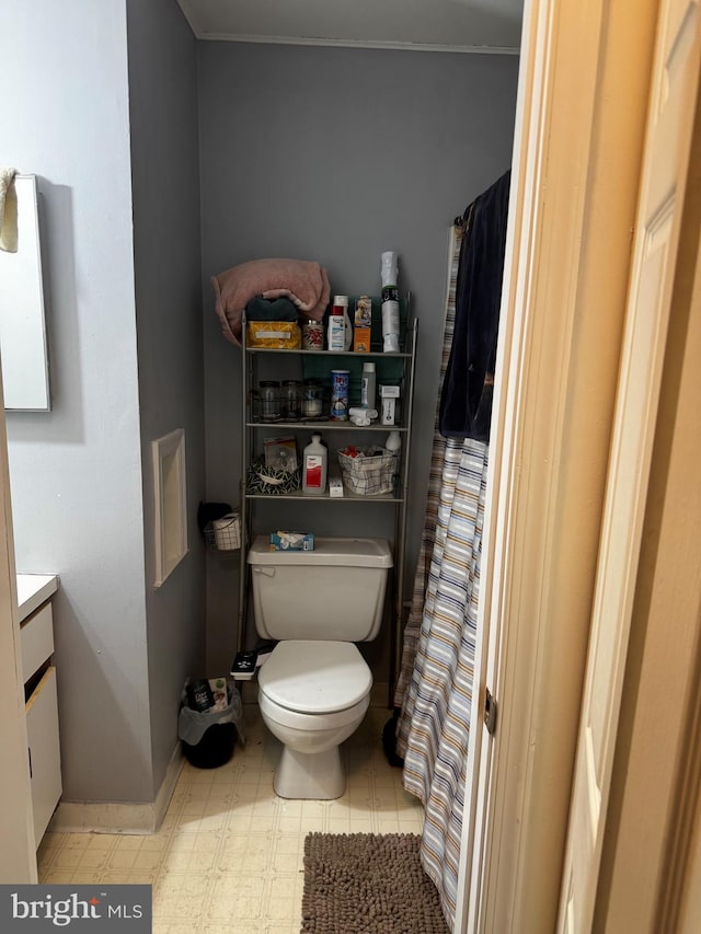 bathroom featuring curtained shower, toilet, vanity, and baseboards