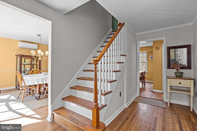 stairs featuring crown molding, a chandelier, hardwood / wood-style floors, and a wall mounted AC