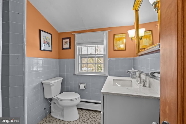 bathroom featuring a wainscoted wall, tile walls, toilet, and vanity