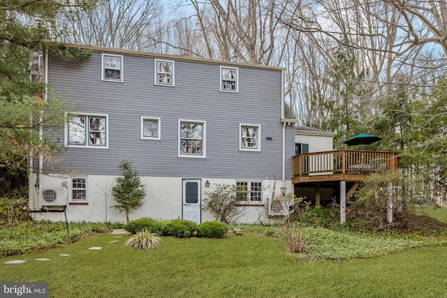 rear view of house with ac unit, a lawn, and a wooden deck