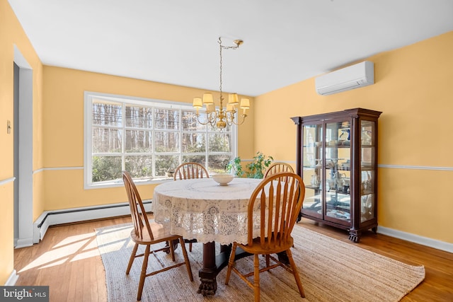 dining area with a baseboard heating unit, a chandelier, wood finished floors, and a wall mounted air conditioner