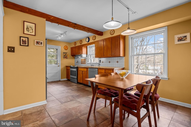 kitchen with beam ceiling, brown cabinets, stainless steel appliances, tasteful backsplash, and a sink