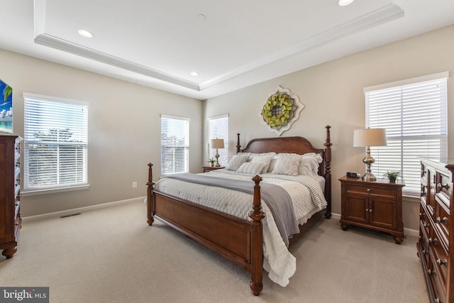 bedroom with light carpet, baseboards, a raised ceiling, and recessed lighting