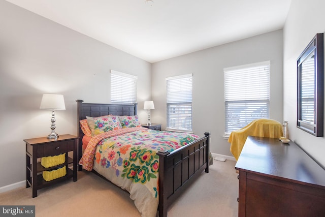 bedroom with baseboards and light colored carpet