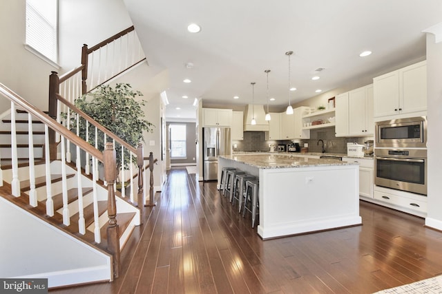 kitchen featuring stainless steel appliances, dark wood-type flooring, a kitchen island, decorative backsplash, and open shelves