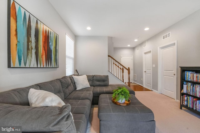 carpeted living area with recessed lighting, visible vents, and stairs