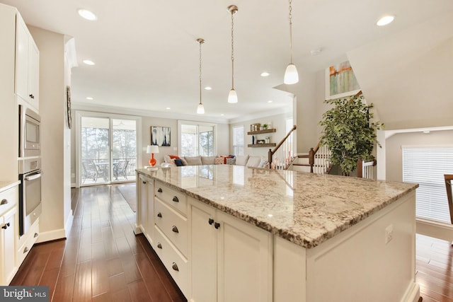 kitchen featuring recessed lighting, stainless steel appliances, dark wood-type flooring, a center island, and light stone countertops