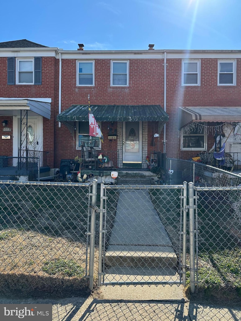 view of property featuring a gate and brick siding