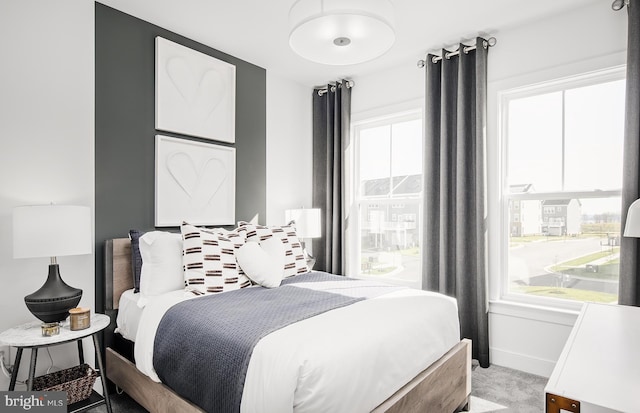 bedroom featuring light carpet and baseboards