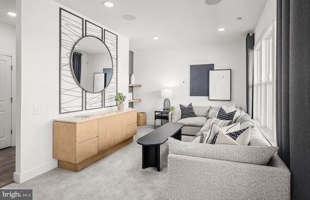 living room featuring light carpet, baseboards, and recessed lighting