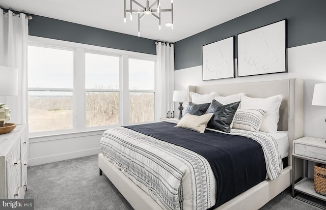 carpeted bedroom featuring a chandelier, multiple windows, and baseboards