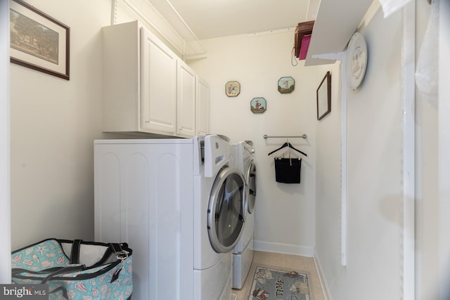 clothes washing area featuring light tile patterned floors, baseboards, cabinet space, and separate washer and dryer