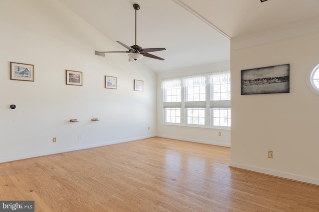 spare room featuring light wood-type flooring, visible vents, a ceiling fan, baseboards, and vaulted ceiling