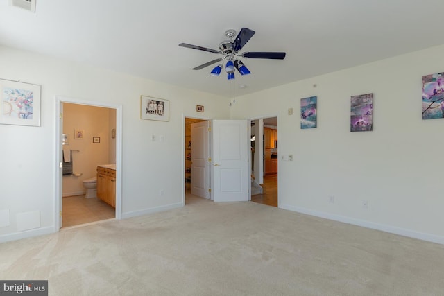 unfurnished bedroom featuring ensuite bath, baseboards, and light carpet