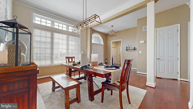 dining room featuring a wealth of natural light, baseboards, wood finished floors, and ornamental molding