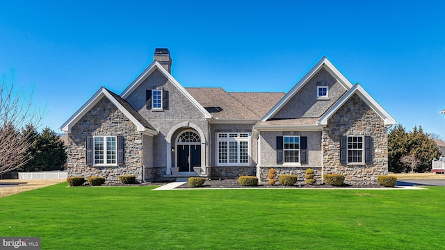 craftsman inspired home with stucco siding, a chimney, and a front lawn