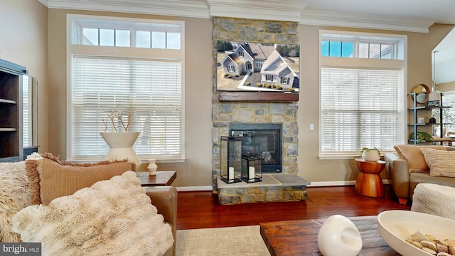 living room featuring crown molding, wood finished floors, a fireplace, and baseboards