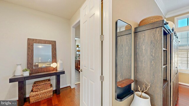 bathroom with crown molding, wood finished floors, and baseboards