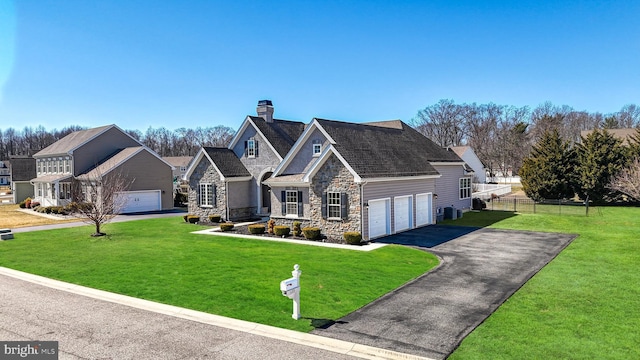 view of front of property with a front yard, fence, a chimney, stone siding, and aphalt driveway