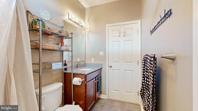 bathroom featuring vanity, tile patterned floors, and toilet