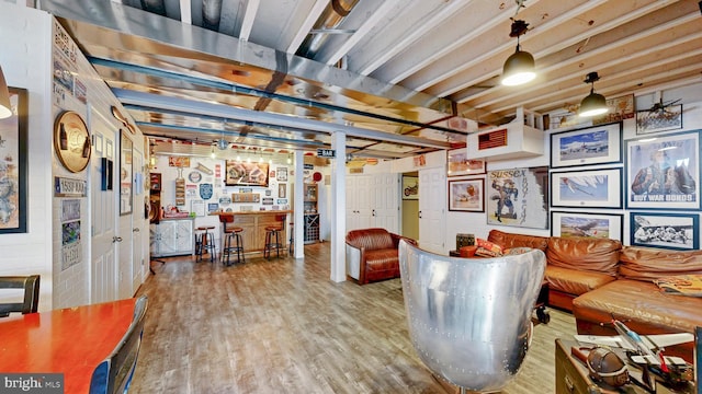 living area featuring a bar and wood finished floors