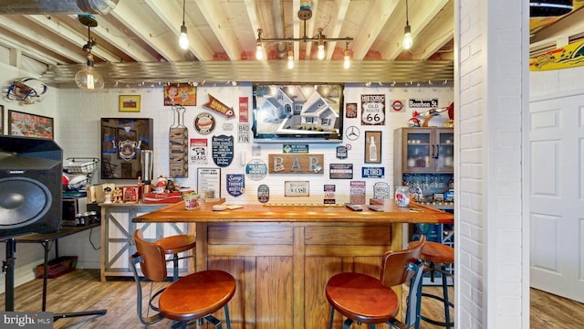 bar with a dry bar and wood finished floors