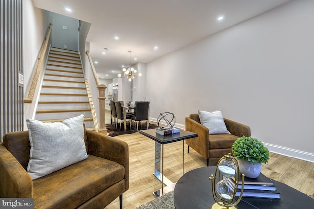 living area with wood finished floors, baseboards, recessed lighting, stairs, and a chandelier