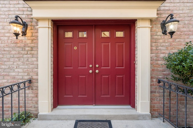 view of exterior entry featuring brick siding