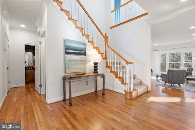 entrance foyer with baseboards, stairs, ornamental molding, and wood finished floors