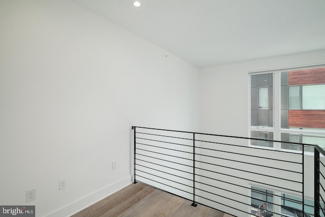 spare room featuring baseboards, wood finished floors, and recessed lighting