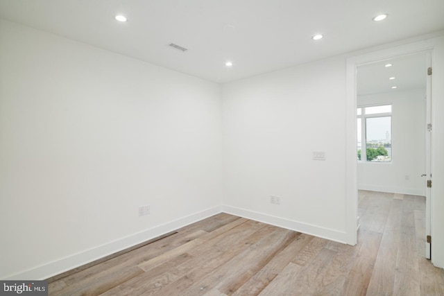 empty room featuring visible vents, recessed lighting, light wood-style flooring, and baseboards