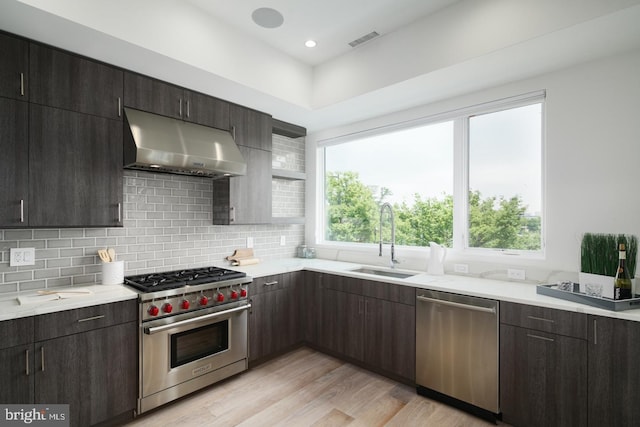 kitchen featuring stainless steel appliances, light countertops, visible vents, a sink, and under cabinet range hood