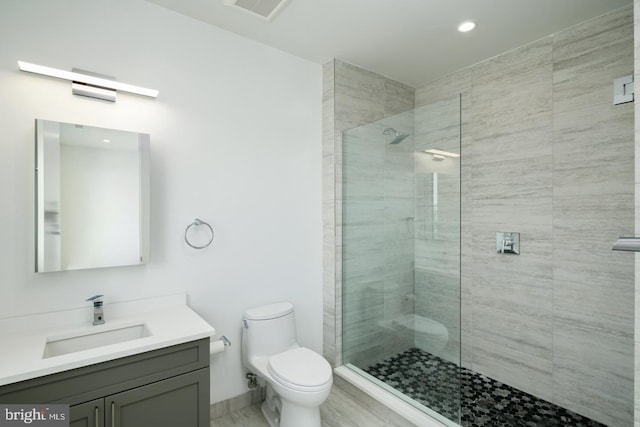 bathroom with baseboards, visible vents, toilet, walk in shower, and vanity