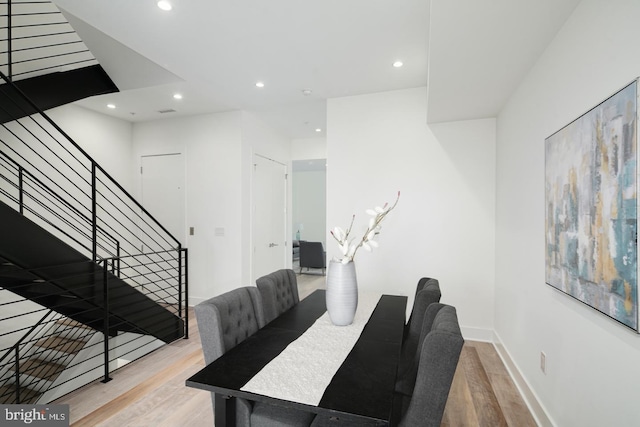 dining space featuring baseboards, stairway, wood finished floors, and recessed lighting