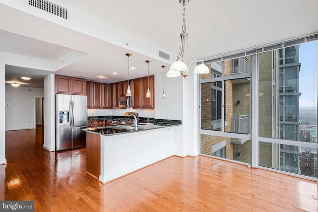 kitchen featuring hardwood / wood-style floors, a wall of windows, visible vents, and appliances with stainless steel finishes