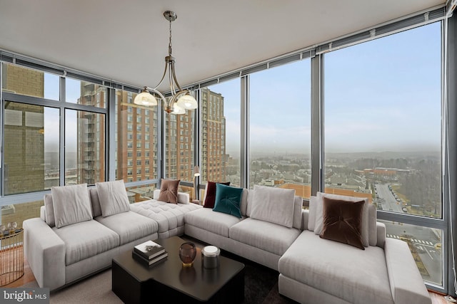 sunroom featuring a view of city, plenty of natural light, and an inviting chandelier