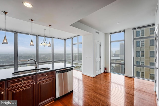 kitchen featuring a wall of windows, visible vents, dark wood finished floors, a sink, and dishwasher