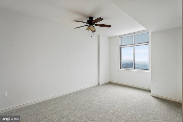 empty room featuring a ceiling fan, carpet, and baseboards