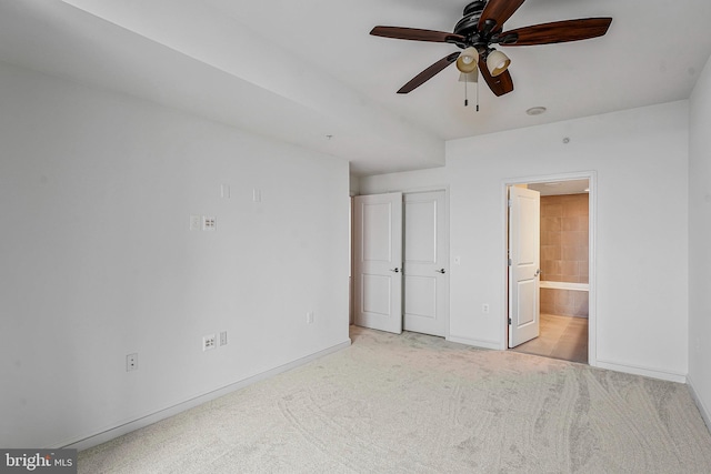 unfurnished bedroom with ensuite bathroom, baseboards, and carpet floors