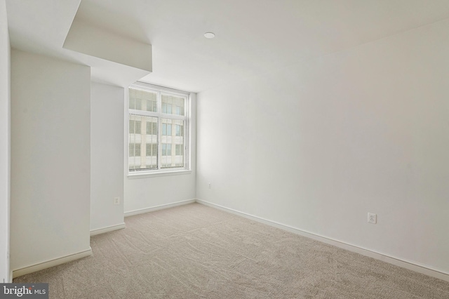 carpeted empty room featuring baseboards