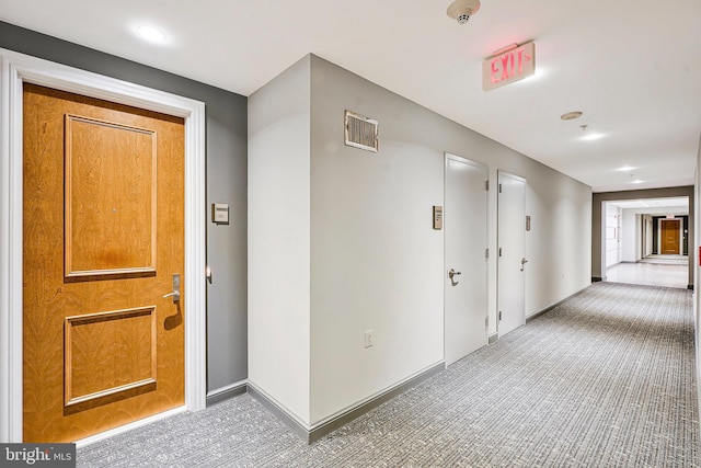 corridor featuring carpet flooring, baseboards, and visible vents